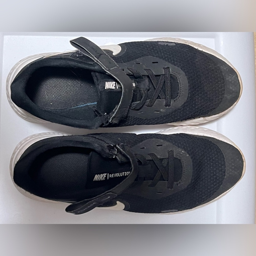 Lightly used Boys Nike revolution shoes size 4.5 color black. Velcro strap.
